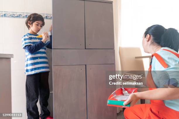 photo of mother ans son painting kitchen cabinet at home - 40 44 ans stock pictures, royalty-free photos & images