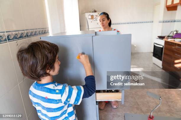 photo of mother ans son painting kitchen cabinet at home - 40 44 ans stock pictures, royalty-free photos & images