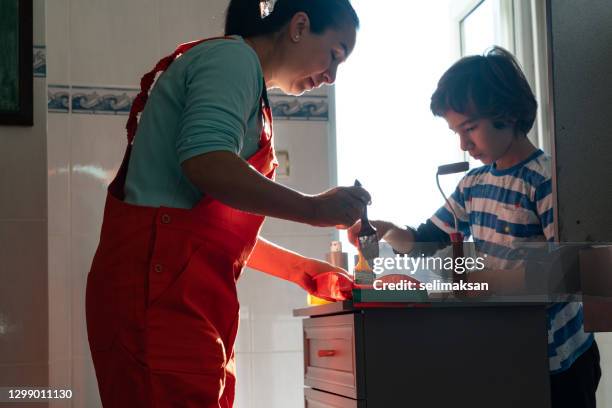 photo of mother ans son painting kitchen cabinet at home - 40 44 ans stock pictures, royalty-free photos & images