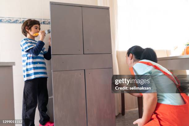 photo of mother ans son painting kitchen cabinet at home - 40 44 ans stock pictures, royalty-free photos & images