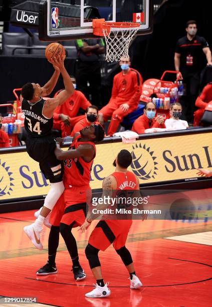 Giannis Antetokounmpo of the Milwaukee Bucks shoots over Pascal Siakam of the Toronto Raptors during a game at Amalie Arena on January 27, 2021 in...