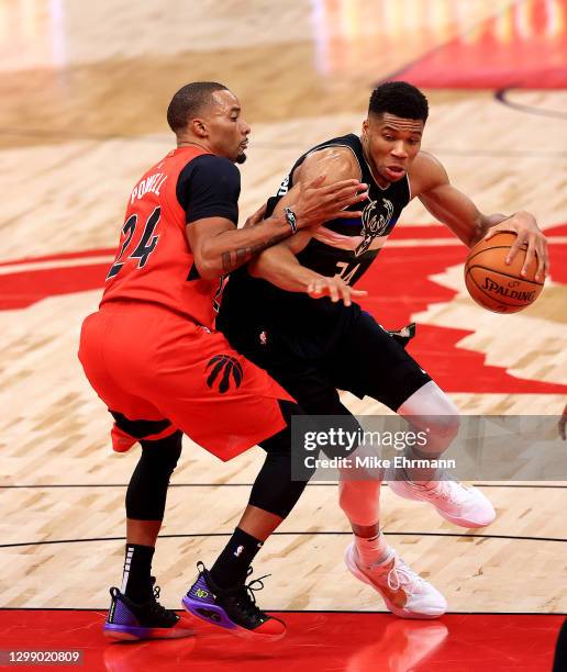 Giannis Antetokounmpo of the Milwaukee Bucks drives on Norman Powell of the Toronto Raptors during a game at Amalie Arena on January 27, 2021 in...