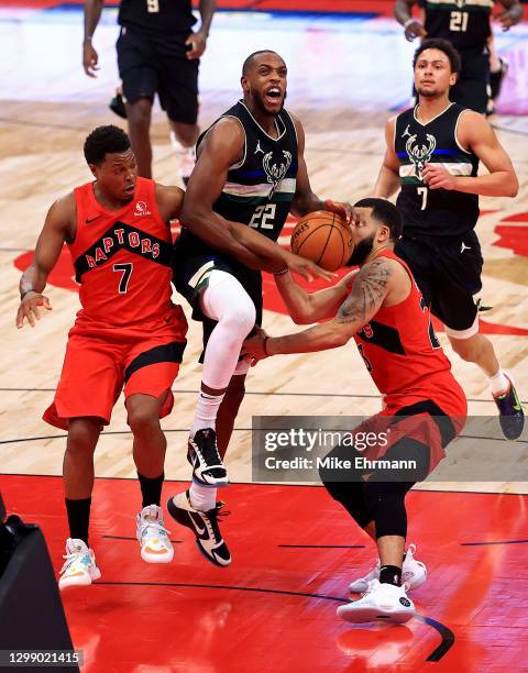 Khris Middleton of the Milwaukee Bucks drives on Fred VanVleet and Kyle Lowry of the Toronto Raptors during a game at Amalie Arena on January 27,...