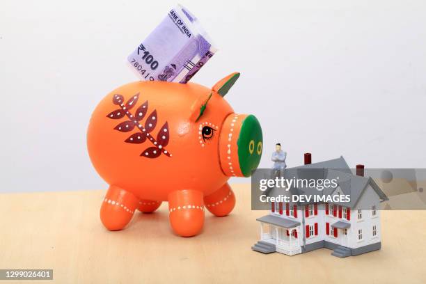 concept of money savings-piggy bank and miniature house - indian rupee coin stock-fotos und bilder