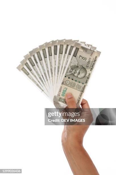 holding indian currency notes against white background - indian rupee bildbanksfoton och bilder