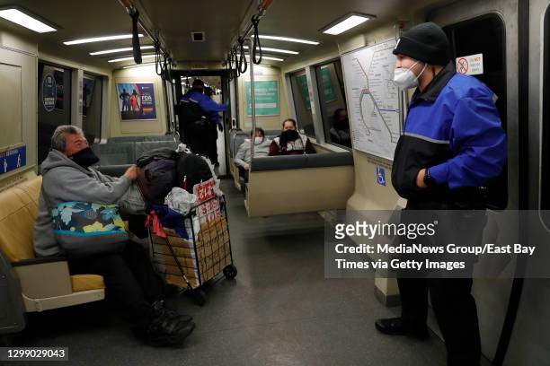 Ambassador Romero Dontaye talks with a homeless man as he rides a train from Oakland to San Francisco, Calif., on Wednesday, Jan. 13, 2021. The...