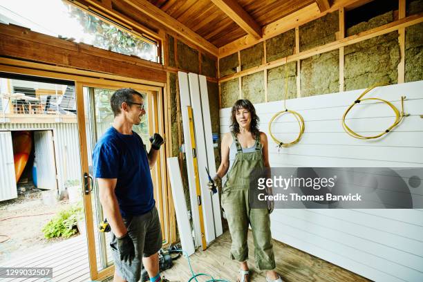 smiling couple working on improvement project - khaki shorts stock pictures, royalty-free photos & images