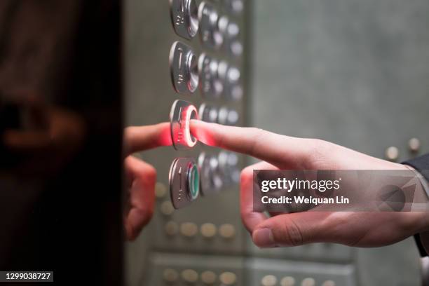 a hand is pushing a button - elevator fotografías e imágenes de stock