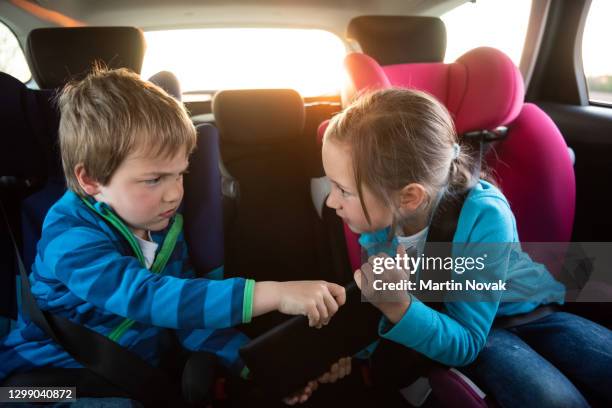 kids in car fighting for tablet - girl in car with ipad stock-fotos und bilder