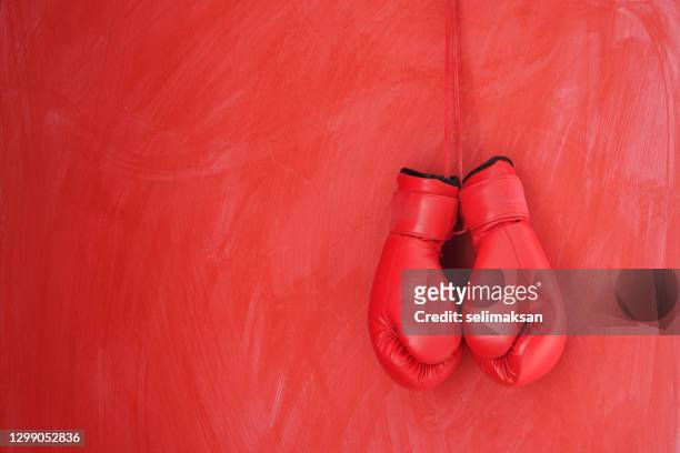 foto di guanti da boxe rossi appesi al muro rosso - boxing gloves foto e immagini stock