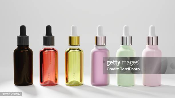 set of glass bottles with colorful oil droplet essentials on white background - oil liquid ストックフォトと画像