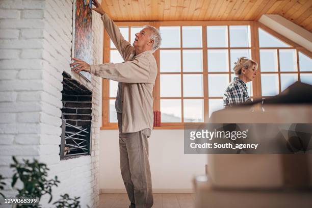 senior couple moving in their new home - house for an art lover stock pictures, royalty-free photos & images