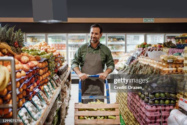 lateinamerikanische angestellte - gemüsehändler im supermarkt - gemüseladen stock-fotos und bilder