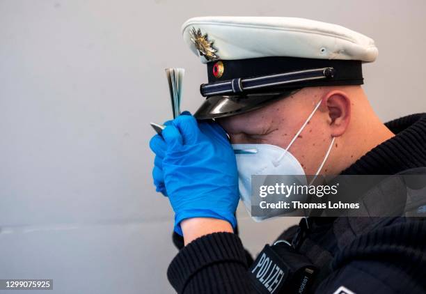 Border police officer checks a passport of a passengers arriving on a flight from Spain at Frankfurt Airport during the second wave of the...