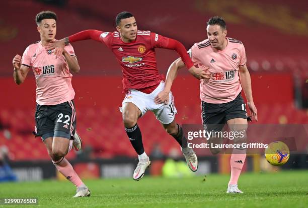 Mason Greenwood of Manchester United is held back Ethan Ampadu and Phil Jagielka of Sheffield United during the Premier League match between...