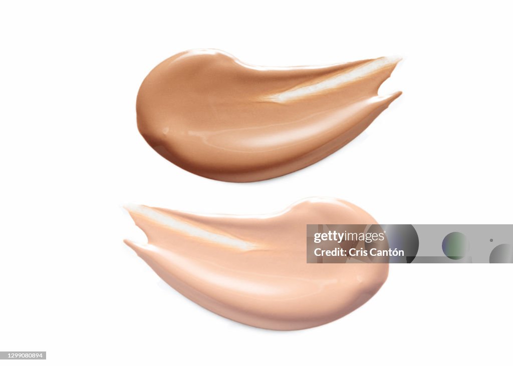 Dark and light liquid foundation samples on white background