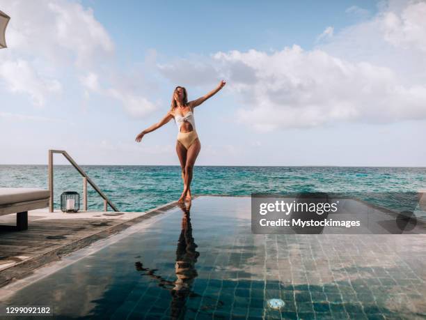 de wandelingen van de vrouw op de rand van een infinity pool over ertsade - infinity loop stockfoto's en -beelden