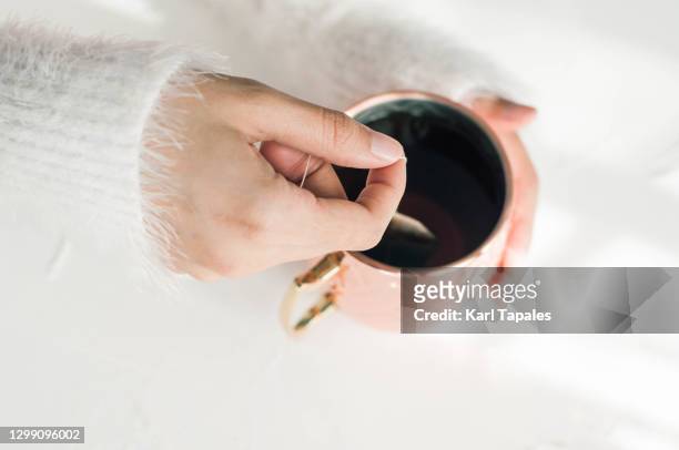 a young woman is steeping a tea on a metallic cup - hot filipina women stock pictures, royalty-free photos & images