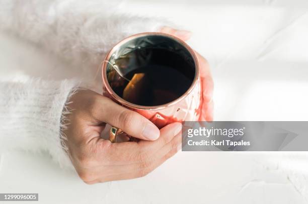 a young woman is steeping a tea on a metallic cup - hot filipina women stock pictures, royalty-free photos & images