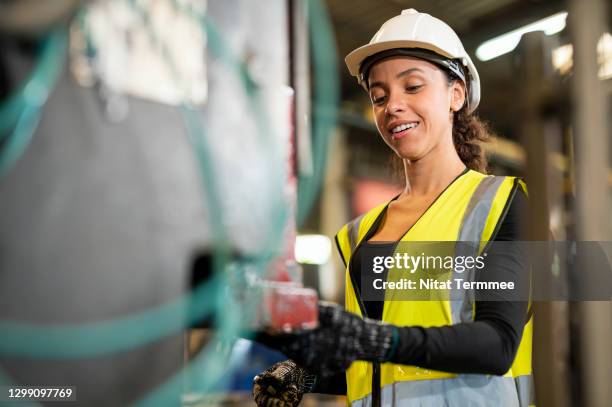 a positive work environment concepts. a latin female worker are happy to carry out their assignments in the production line of auto parts in factory. - production line worker stock pictures, royalty-free photos & images