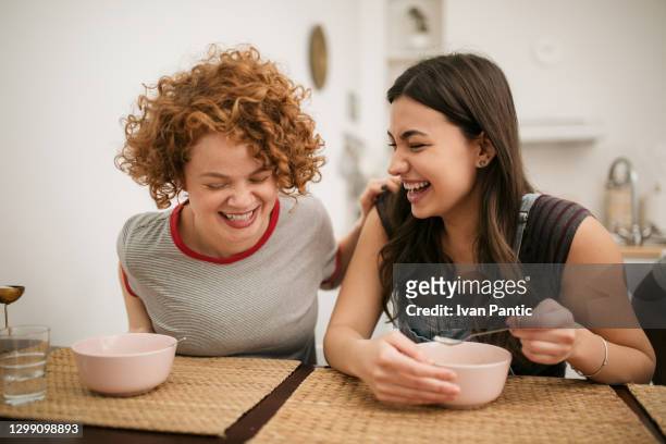two caucasian female having a meal at home - college dorm party stock pictures, royalty-free photos & images