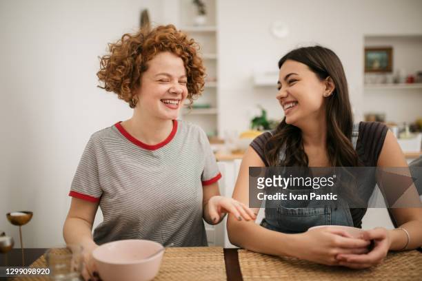 zwei kaukasische weibchen beim essen zu hause - college dorm party stock-fotos und bilder