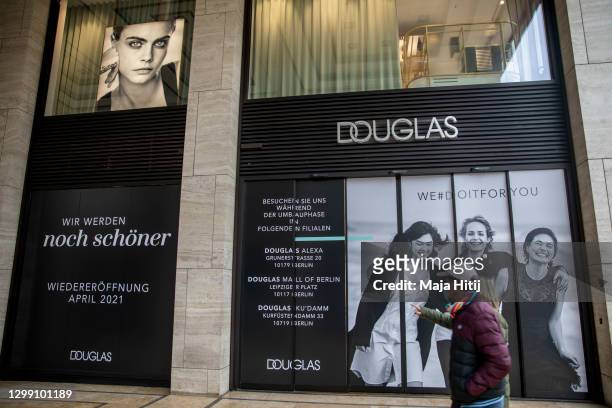 Woman walks past a closed Douglas perfumery chain during the second wave of the coronavirus pandemic on January 28, 2021 in Berlin, Germany. Due to...