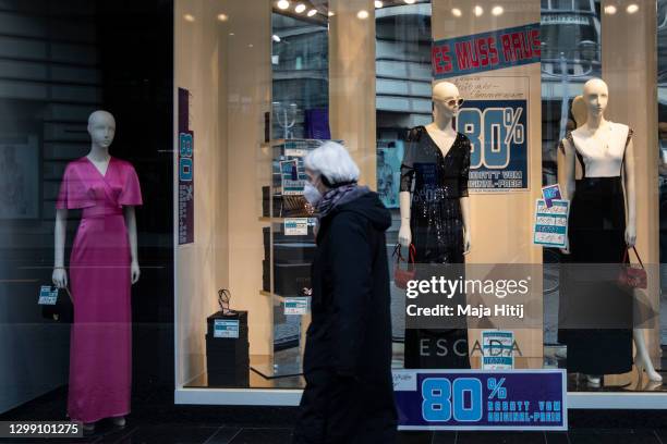 Woman walks past a closed shop offering discount due closing during the second wave of the coronavirus pandemic on January 28, 2021 in Berlin,...