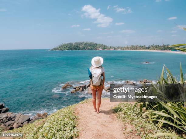 rear view of woman contemplating seascape from top of cliff - sri lanka woman stock pictures, royalty-free photos & images