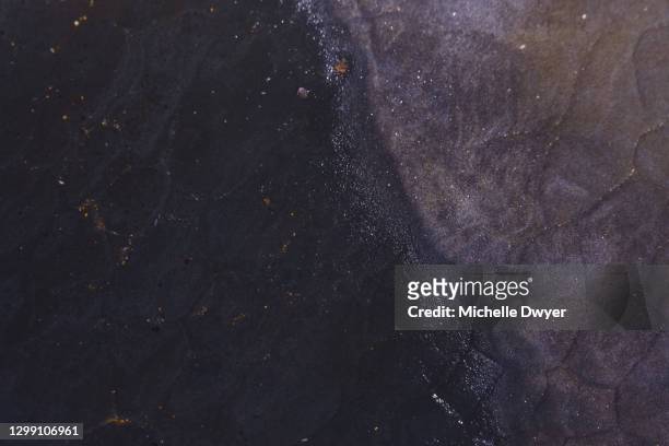 imaginary galaxies sunlight and water on rocks dark - dark ocean ripples stockfoto's en -beelden