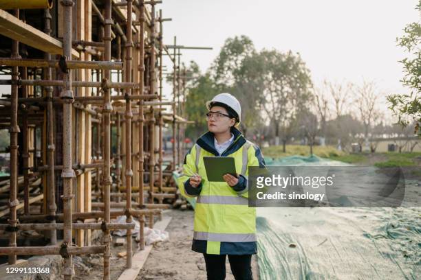 asian female engineer working in construction site - leanincollection stock pictures, royalty-free photos & images
