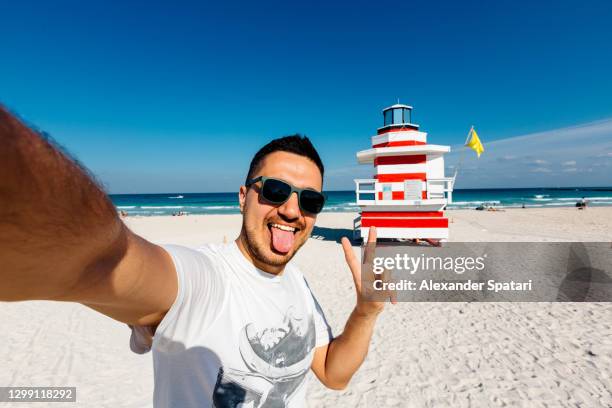 young man in sunglasses taking a selfie at south beach, miami, usa - miami party stock pictures, royalty-free photos & images