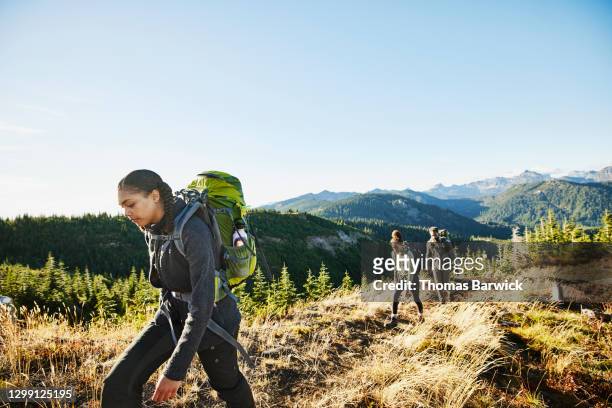 young woman leading sister and father on backpacking trip - escursionismo foto e immagini stock