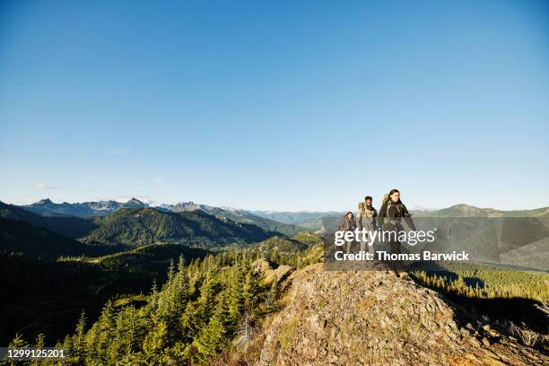 father and daughters hiking on rocky ridge during backpacking trip - noroeste pacífico de los estados unidos fotografías e imágenes de stock