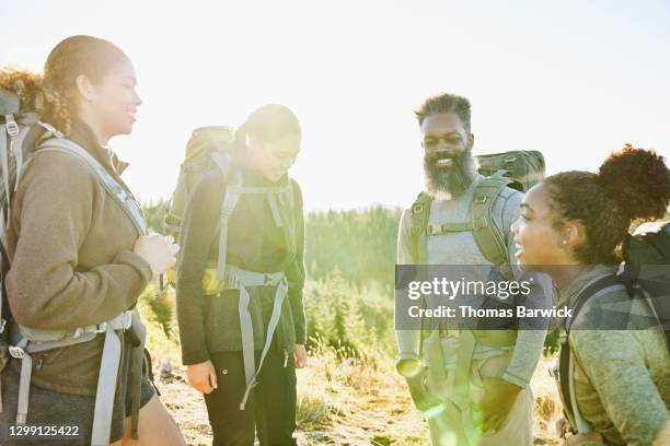 smiling father in discussion with daughters while on backpacking trip - travel16 stock pictures, royalty-free photos & images