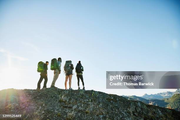 father and daughters enjoying view from ridge during backpacking trip - great american group stock pictures, royalty-free photos & images