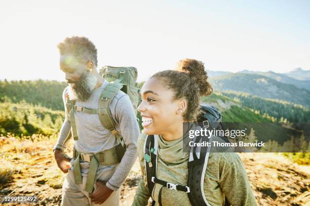 smiling daughter and father on backpacking trip on fall afternoon - spirit of america stock pictures, royalty-free photos & images