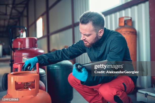 男性工人在液化氣體儲存中用數字平板電腦檢查氣缸 - flammable 個照片及圖片檔