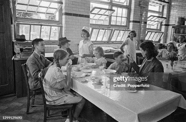 Mrs Scriven and her children enjoy a mid day meal at a recently opened British Restaurant in Gillingham, Kent, England during World War II in August...