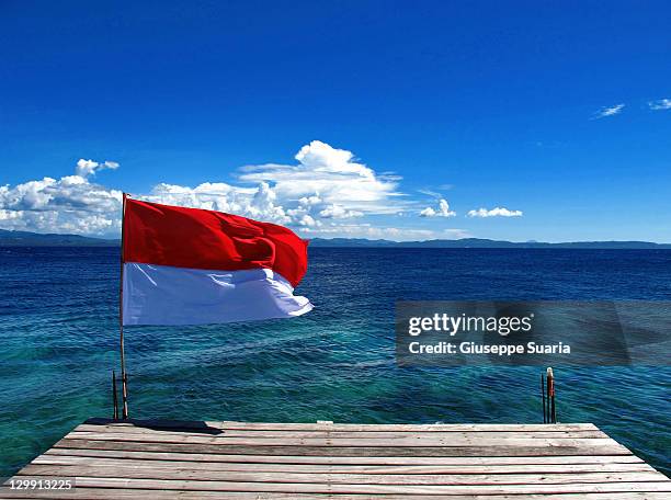 indonesian flag flying on jetty - indonesia flag stock pictures, royalty-free photos & images