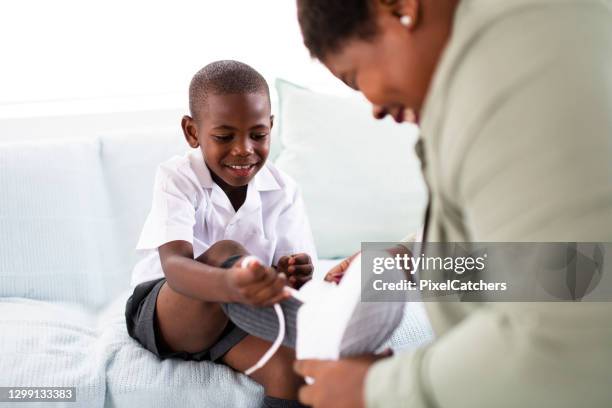 excited little boy tying shoelaces on new school shoes - boy tying shoes stock pictures, royalty-free photos & images