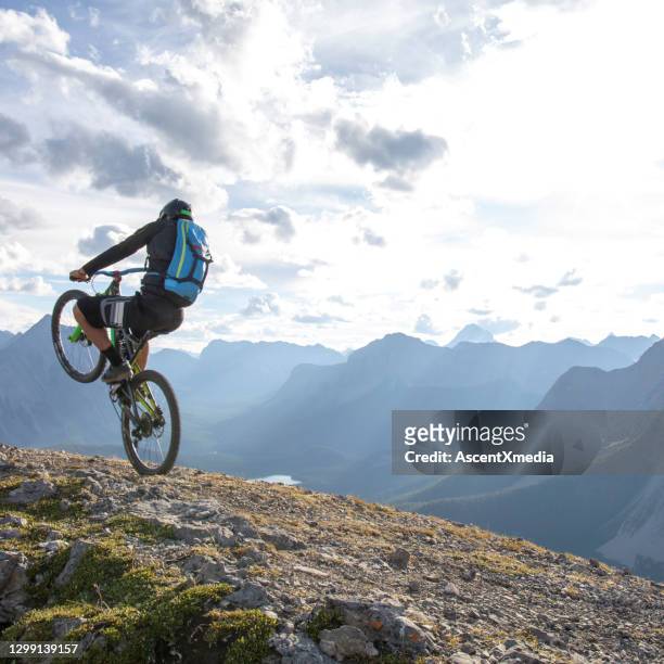 mountain biker pops a wheelie on mountain ridge in the morning - change agility stock pictures, royalty-free photos & images