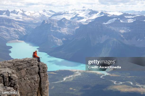 female mountaineer relaxes on mountain ridge in the morning - climbing snow mountain imagens e fotografias de stock