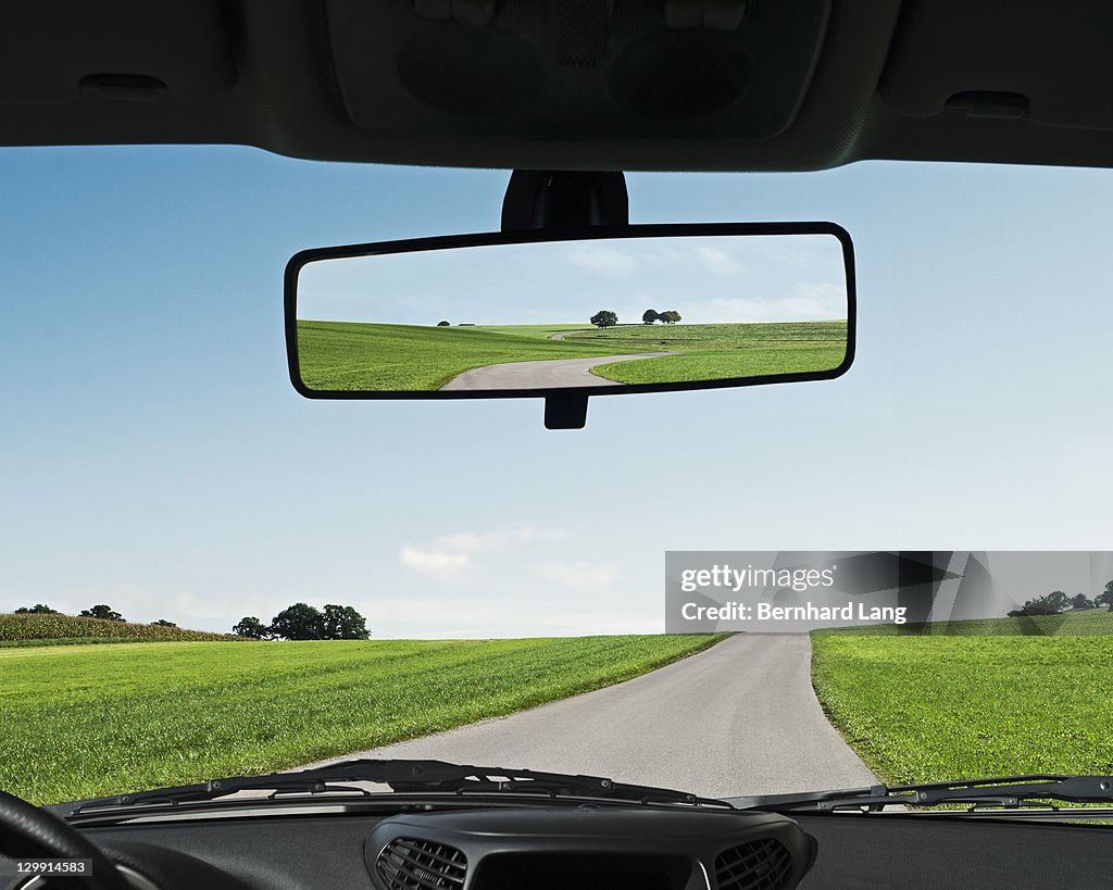 Road reflected in rear view mirror, close-up