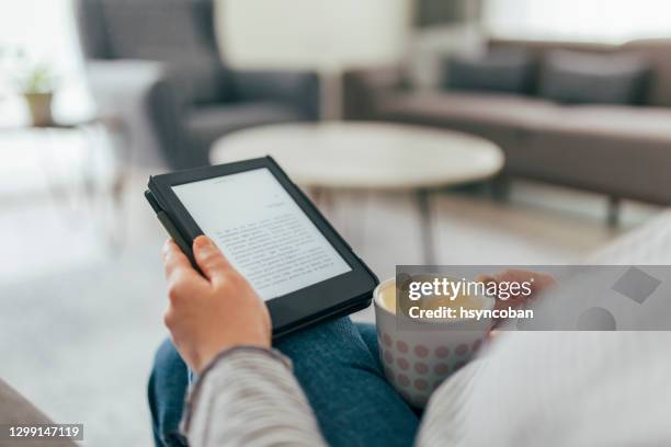 mujer leyendo e-book en casa - lector de libros electrónicos fotografías e imágenes de stock
