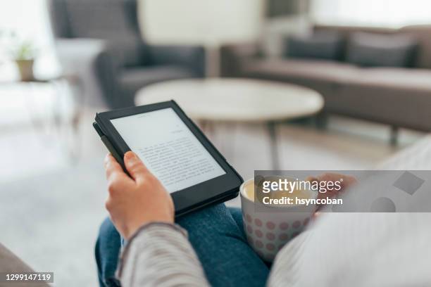 woman reading e-book at home - e reader stock pictures, royalty-free photos & images