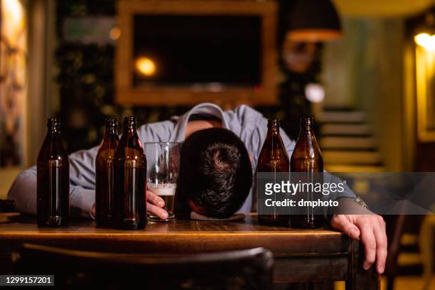 young drunk man sleeping on bar counter - alcohol abuse stock pictures, royalty-free photos & images