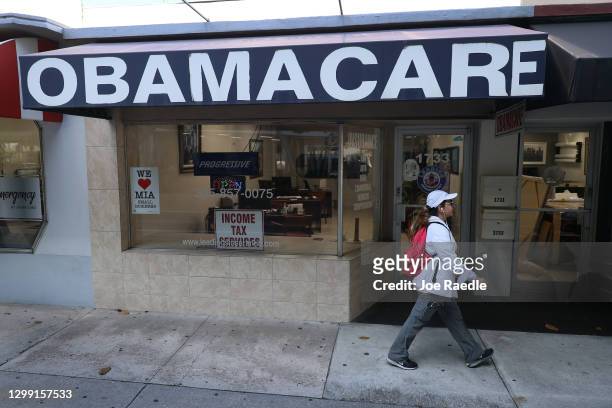 Pedestrian walks past the Leading Insurance Agency, which offers plans under the Affordable Care Act on January 28, 2021 in Miami, Florida. President...