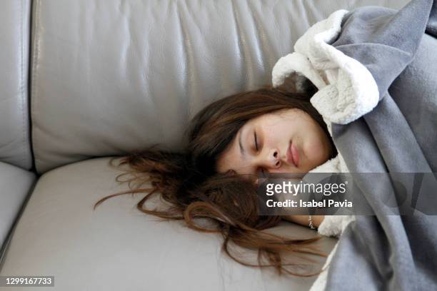 sick woman sleeping on sofa - langes haar stock-fotos und bilder