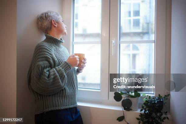 The Man Looks Outside Standing At The Open Window Of His Apartment Staying  At Home During The Epidemic And Quarantine Stock Photo - Download Image Now  - iStock